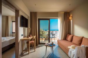 a hotel room with a couch and a balcony at Hotel Pyriá in Hersonissos