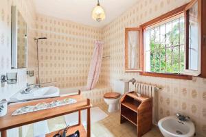 Un baño con lavabo, inodoro y ventana. en Villa Tamaris, en Santa Eulària des Riu 21 fotos más