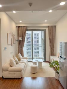 a living room with a couch and a large window at Bunnys Homes - Managed by WiWi - Vinhomes Ocean Park in Hanoi +222 photos