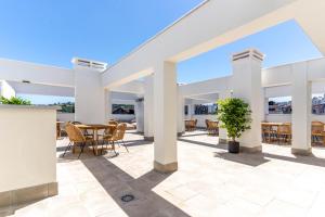 a patio with tables and chairs in a building at Limehome Oviedo Calle Postigo Bajo in Oviedo