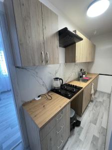 a kitchen with wooden cabinets and a stove top oven at pokoje do wynajęcia in Grajewo +45 photos
