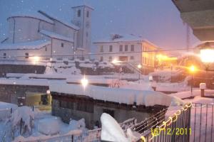 eine Stadt voller Schnee in der Nacht mit Gebäuden in der Unterkunft Casa Elisa in Doues + 4 Fotos