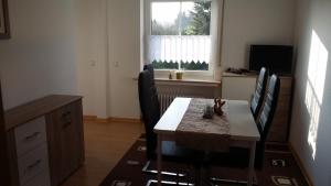 a dining room with a table and chairs and a window at Ferienwohnung Debray in Winterberg