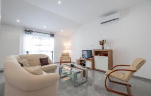 a living room with a white couch and chairs at 6 Bedroom Awesome Home In Prolozac in Donji Proložac