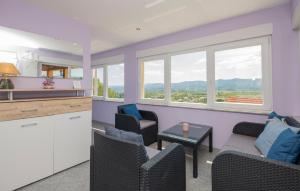 a kitchen and living room with purple walls and windows at 6 Bedroom Awesome Home In Prolozac in Donji Proložac