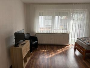 a living room with a television and a chair and a desk at Ferienwohnung Grimm 3 in Pforzheim