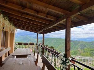 a wooden table on a balcony with a view of mountains at Villa Garden in Kremen