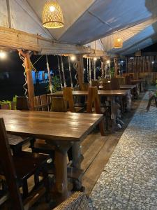 a row of wooden tables and chairs in a restaurant at Brown Bamboo Bukit Lawang Trekking in Bukit Lawang