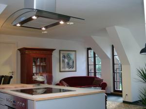 a living room with a kitchen with a ceiling fan at Ferienwohnung Am Dom in Xanten