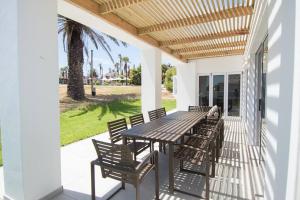 a patio with a table and chairs on a porch at Odyssey - journey to paradise in St Helena Bay