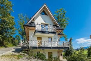 a house with a balcony on the side of it at OMORIKA - Wierch Rusiński in Bukowina Tatrzańska