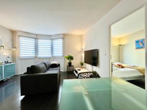a living room with a couch and a bed at Le Forville Centre avec Parking in Reims
