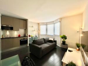 a living room with a couch and a kitchen at Le Forville Centre avec Parking in Reims