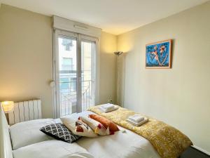 a bedroom with a bed with pillows and a window at Le Forville Centre avec Parking in Reims