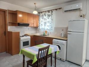 a kitchen with a table and a white refrigerator at Apartment Kasper in Skiathos Town