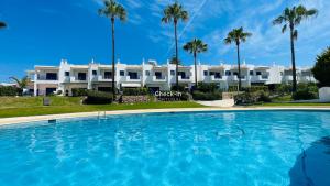 a large swimming pool in front of a large white building at Jardim da Oura - Shared Pool - 6 Guests - Albufeira in Albufeira
