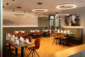 a restaurant with tables and chairs in a room at TARGET WORLD Hunter's Lodge in Landscheid