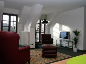 sala de estar con 2 sillas y TV en Ferienwohnung Am Dom, en Xanten