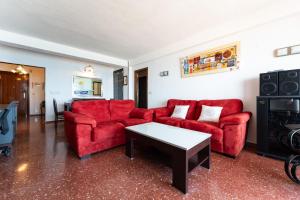 a living room with red couches and a table at CT 307 AL - Faro's Zapillo Apartment - Almeria in Almería