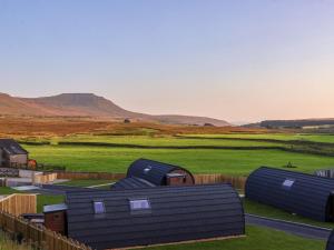a group of buildings in a field with mountains in the background at Barn Owl in Carnforth