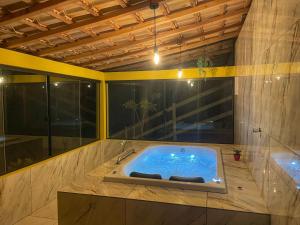 a bathroom with a jacuzzi tub in a room at Sítio Ramos casa amarela in Cunha +43 photos