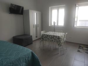 a bedroom with a table and chairs and a television at Cirella House in Cirella