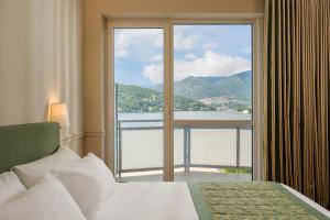 una camera da letto con un letto e una grande finestra di Hotel Barchetta Excelsior a Como