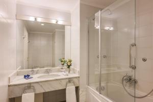 a white bathroom with a sink and a shower at Hotel Barchetta Excelsior in Como