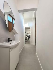 ein Badezimmer mit Waschbecken und Spiegel an der Wand in der Unterkunft Matteotti Royale Apartments in Syrakus