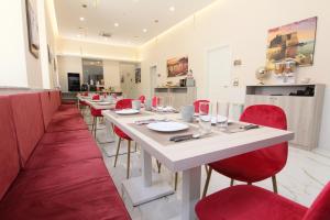 a dining room with red chairs and a white table at AuRoom in Naples