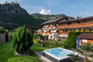 a resort with a swimming pool in the yard at Hotel Bischofhof - Bistro Jasmin in Chiusa