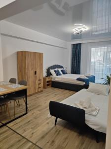 a bedroom with two beds and a table and a dining room at DelEric apartments in Eforie Nord
