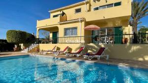 a house with a swimming pool in front of a house at Margarida by Check-in Portugal in Albufeira