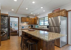 a kitchen with a stainless steel refrigerator and bar with stools at Reflection Bay in Winchester