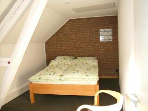 Bett in einem Zimmer mit Ziegelwand in der Unterkunft Ferienwohnung Am Dom in Xanten