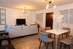a living room with a couch and a table with chairs at Prime Location Stylish Apartment in San Pedro Sula +8 photos