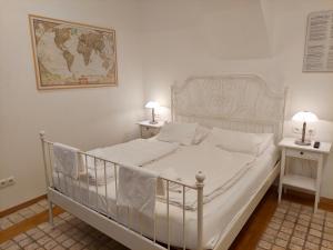 a white bed in a bedroom with two night stands at Modern Studios near City Center in Vienna