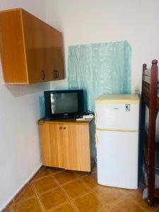 シュコダルにあるVilson gest houseの小型冷蔵庫の上に置かれた小型テレビ