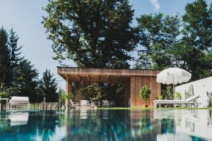 a swimming pool with a house and an umbrella at theoldschool guesthouse in Grosswalz