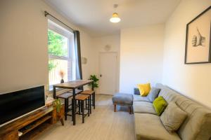 una sala de estar con un sofá y una mesa en Brislington Base Super Convenient Apartment In South West By StayStaycations, en Bristol