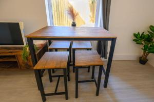 Una mesa de madera con cuatro taburetes y una mesa y sillas. en Brislington Base Super Convenient Apartment In South West By StayStaycations, en Bristol 23 fotos más