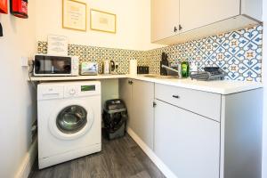 Una pequeña cocina con lavadora. en Brislington Base Super Convenient Apartment In South West By StayStaycations, en Bristol