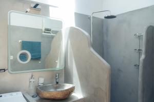a bathroom with a stone sink and a mirror at Rena's Dream in Artemonas +1 photo