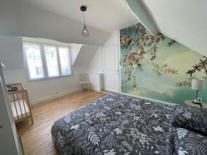 ein Schlafzimmer mit einem Bett und einem Gemälde an der Wand in der Unterkunft Charmante maison tourangelle proche Amboise in Mosnes