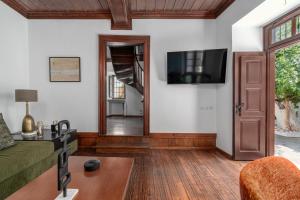 a living room with a couch and a television at Telegraphus Boutique Home in Skiathos