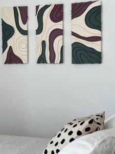 a bedroom with three paintings on the wall at Casa dei Sogni in Scalea