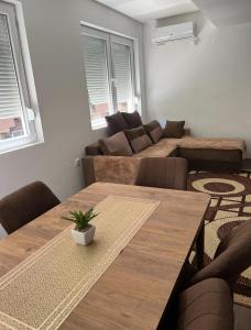 a living room with a wooden table and a couch at Downtown Great Apartment in Strumica