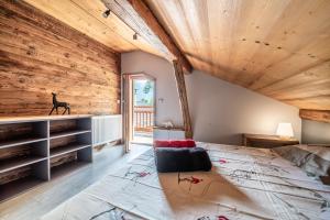 una camera con un grande letto e soffitti in legno di Chalet La Glière de l'Etelley a Samoëns