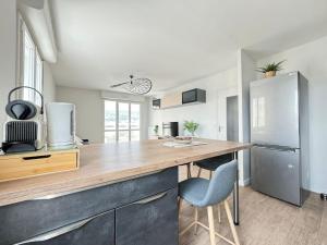 Il comprend une cuisine équipée d'un comptoir en bois et d'un réfrigérateur. dans l'établissement Jolie F3 Berthelot , Tout Equipé - WI-FI , CL-FD Berthelot 10eme, à Clermont-Ferrand