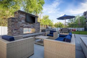 a patio with a stone fireplace with a tv on it at Stylish Apartment Close to Attractions in Salt Lake City
